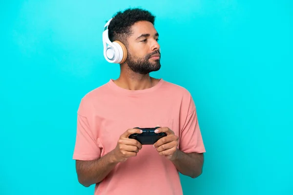 Junger Brasilianischer Mann Spielt Mit Einem Videospielcontroller Auf Blauem Hintergrund — Stockfoto