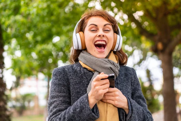 Mujer Morena Escuchando Música Con Auriculares Aire Libre Sorprendida Enviando —  Fotos de Stock