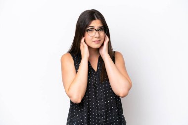 Beyaz arka planda izole edilmiş genç Brezilyalı kadın hayal kırıklığına uğramış ve kulaklarını kapatmış.