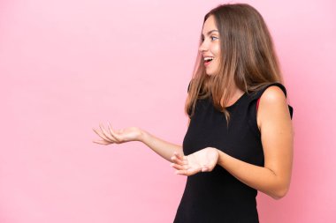 Pembe arka planda mahsur kalmış beyaz bir kadın. Sürpriz bir ifadeyle yan yana bakarken.