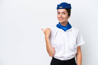 Uçak hostesi beyaz arka planda izole edilmiş beyaz kadın bir ürünü sunmak için kenarı işaret ediyor.