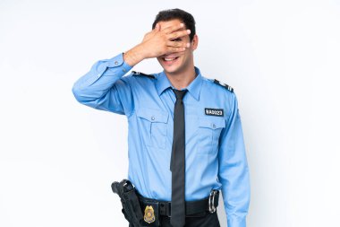 Young police caucasian man isolated on white background covering eyes by hands and smiling