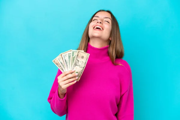 Young Caucasian Woman Taking Lot Money Isolated Blue Background Laughing — Stok fotoğraf
