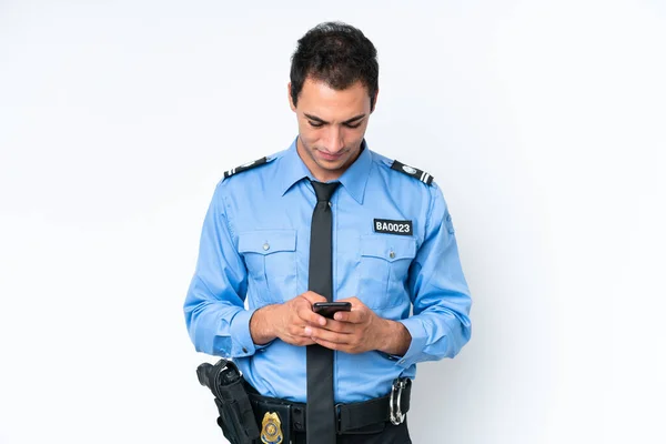 Молодой Кавказский Полицейский Изолированный Белом Фоне Отправляет Сообщение Мобильником — стоковое фото