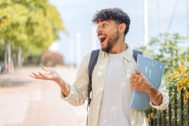 Yüzünde sürpriz bir ifade olan genç Arap öğrenci.