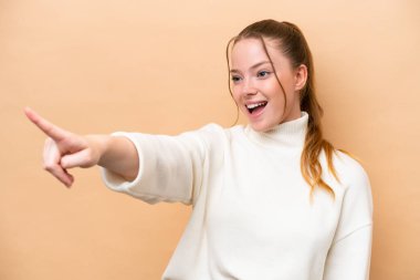 Beyazlı genç bir kadın bej arka planda izole edilmiş.