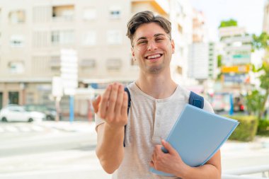 Açık havada genç yakışıklı bir öğrenci benimle gelmesi için davet ediyor. Gelmene sevindim.