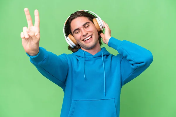 Jovem Homem Bonito Isolado Fundo Croma Verde Ouvir Música Cantar — Fotografia de Stock