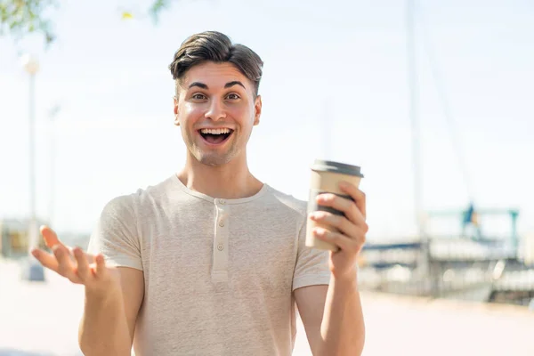 Mladý Pohledný Muž Drží Odnést Kávu Venku Šokovaným Výrazem Obličeje — Stock fotografie