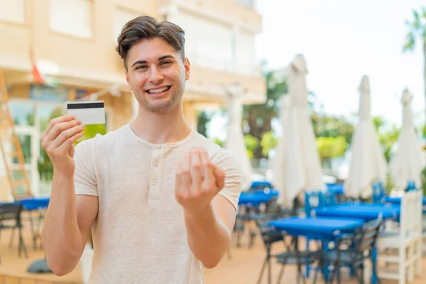 Young Handsome Man Holding Credit Card Outdoors Inviting Come Hand — Stock Photo, Image