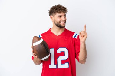 Beyaz arka planda ragbi oynayan beyaz bir adam harika bir fikre işaret ediyor.