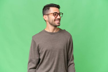 Genç, yakışıklı, beyaz bir adam, soyutlanmış bir geçmişi var. Yan tarafa bakıp gülümsüyor.