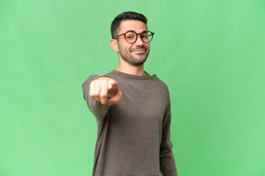 Soyutlanmış geçmişi olan yakışıklı beyaz bir adam mutlu bir ifadeyle öne bakıyor.