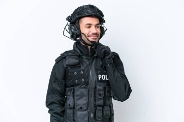Beyaz arka planda izole edilmiş genç beyaz SWAT adamı yan tarafa bakıyor.