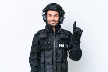 Beyaz arka planda izole edilmiş genç beyaz SWAT elemanı en iyinin işareti olarak parmağını kaldırıyor ve gösteriyor.