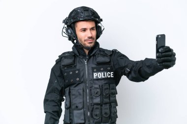 Beyaz arka planda izole edilmiş beyaz fotograf çeken Kafkasyalı genç bir SWAT adamı.