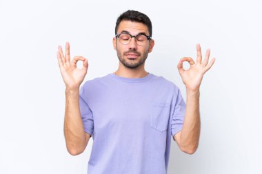 Beyaz arka planda Zen pozisyonunda beyaz tenli genç bir adam