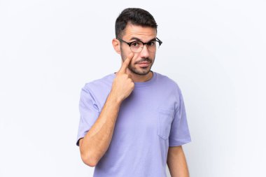 Beyaz arka planda izole edilmiş genç beyaz adam bir şey gösteriyor.