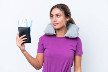 Şişirilebilir Seyahat Yastığı olan genç, güzel Uruguaylı kadın beyaz arka planda izole edilmiş, yan tarafa bakıyor.