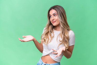 Genç Uruguaylı kadın, yalıtılmış arka planda sürpriz bir ifadeyle yan yana bakarken