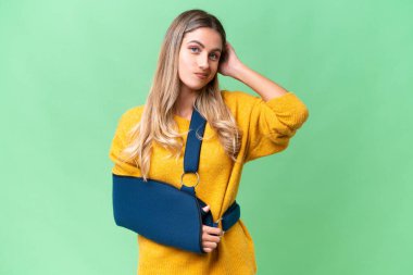 Kırık kollu genç Uruguaylı kadın ve izole edilmiş arka planda askısı var. Şüpheleri var.