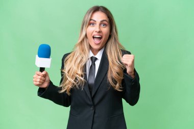 Genç, güzel Uruguaylı televizyon sunucusu izole edilmiş arka planda galibiyeti kutluyor.