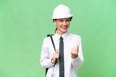 Miğferli genç bir mimar, izole edilmiş arka plan üzerinde planlar tutuyor ve para hareketi yapıyor.