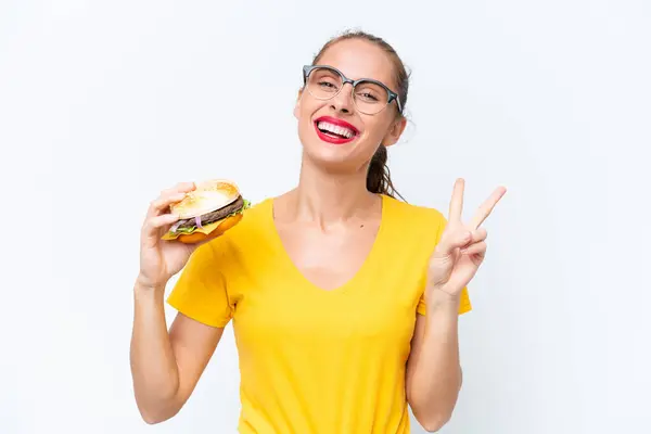 Young Caucasian Woman Holding Burger Isolated White Background Smiling Showing —  Fotos de Stock