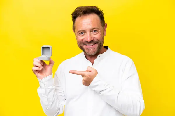 Middle Age Man Holding Engagement Ring Isolated Yellow Background Pointing — Photo