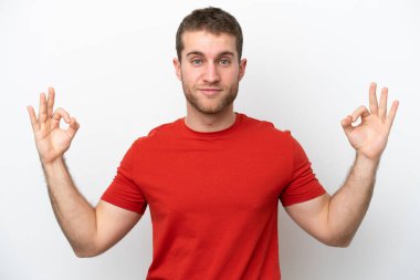 Beyaz arka planda Zen pozisyonunda beyaz tenli genç bir adam