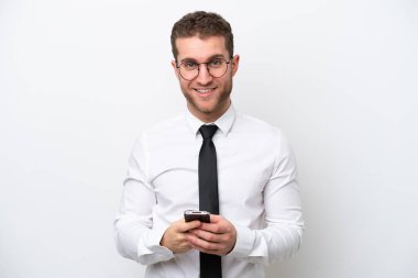 Beyaz arka planda izole edilmiş genç bir beyaz adam cep telefonuyla mesaj gönderiyor.