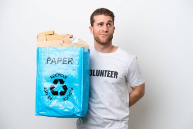 Beyaz arka planda izole edilmiş bir şekilde geri dönüşüm için elinde kağıt dolu bir geri dönüşüm çantası tutan genç beyaz bir adam.