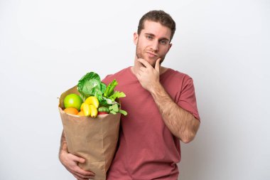 Beyaz arka planda izole edilmiş alışveriş torbası tutan beyaz bir adam.