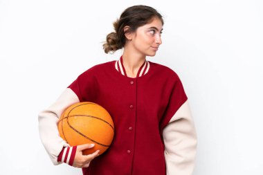 Young basketball player woman isolated on white background looking to the side