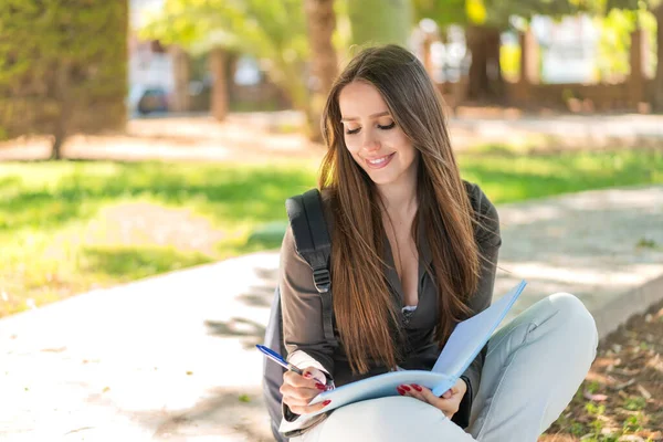 stock image Young woman at outdoors holding a notebook