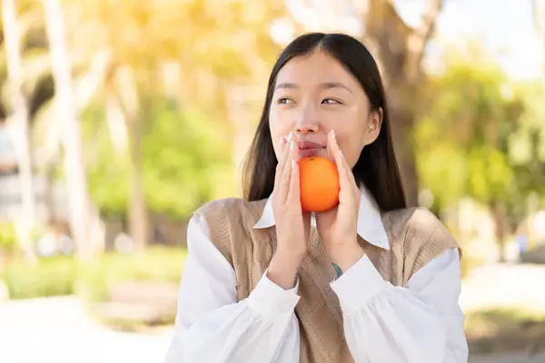 Mooie Chinese Vrouw Buiten Met Een Sinaasappel — Stockfoto