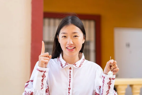 Joven Mujer China Sosteniendo Las Llaves Casa Aire Libre Señalando —  Fotos de Stock