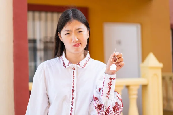 Молода Китайка Тримає Домашні Ключі Відкритому Повітрі Сумним Виразом — стокове фото