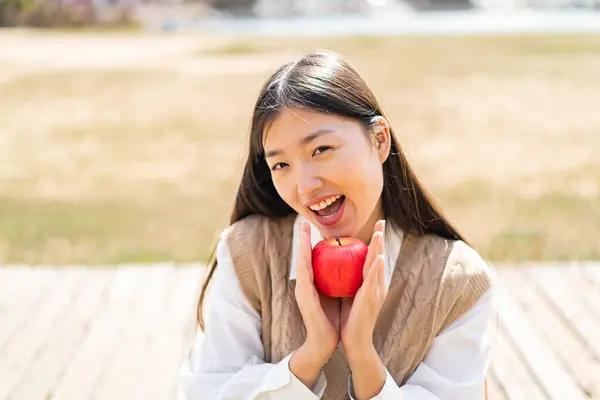 Молода Китайка Відкритому Повітрі Тримає Яблуко Несподіваним Виразом — стокове фото