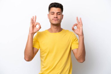 Beyaz arka planda Zen pozisyonunda beyaz tenli genç bir adam