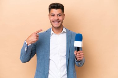 Young caucasian TV presenter man isolated on white background giving a thumbs up gesture