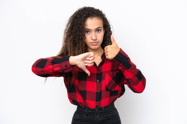 Beyaz arka planda izole edilmiş genç bir Arap kadın iyiye-kötüye işaret veriyor. Evet ya da hayır arasında kararsız