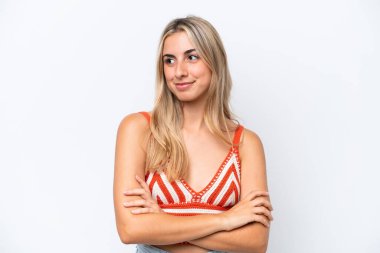 Beyaz arka planda izole edilmiş genç beyaz kadın yan tarafa bakıyor.