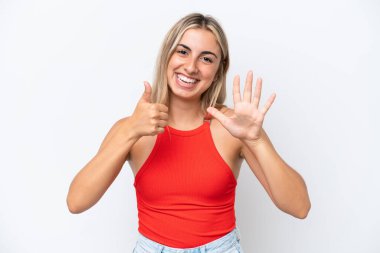 Beyaz arka planda izole edilmiş beyaz tenli genç kadın parmaklarıyla altısını sayıyor.