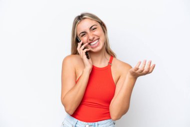Beyaz arka planda izole edilmiş genç beyaz bir kadın cep telefonuyla sohbet ediyor.