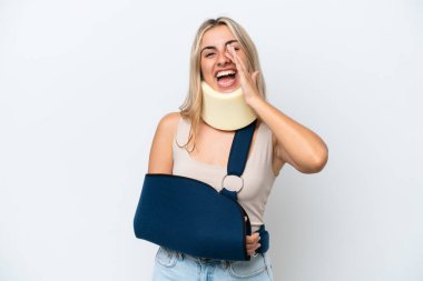 Kırık kollu ve askı takan beyaz arka planda ağzı açık bağıran bir kadın.