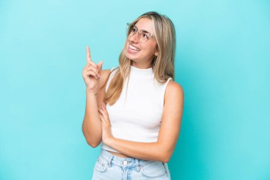 Mavi arka planda izole edilmiş beyaz bir kadın harika bir fikre işaret ediyor.