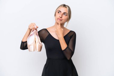 Young caucasian woman practicing ballet isolated on white background having doubts while looking up