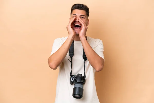 Νεαρός Φωτογράφος Καυκάσιος Άνδρας Απομονωμένος Μπεζ Φόντο Φωνάζοντας Και Ανακοινώνοντας — Φωτογραφία Αρχείου