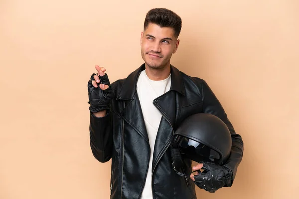 Νεαρός Καυκάσιος Άνδρας Κράνος Μοτοσικλέτας Απομονωμένο Μπεζ Φόντο Δάχτυλα Σταυρώνουν — Φωτογραφία Αρχείου
